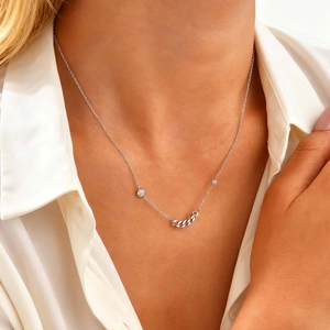 Elegant silver stainless steel chain necklace with zircon accents on a model in white