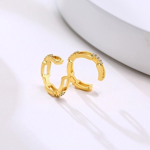 Detail shot of gold-plated chain-link ear cuffs with shimmering zircon inlays