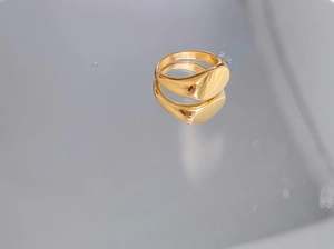 Close-up of a gold-colored minimalist signet ring with a polished oval mirror surface