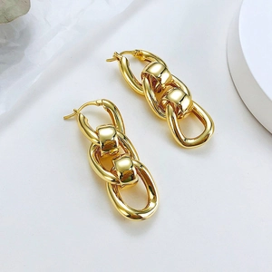 Detail view of bold gold interlocking chunky link earrings with high-polish mirror finish