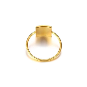 Dettaglio di un anello geometrico dorato minimalista con finitura lucida e fascia sottile
