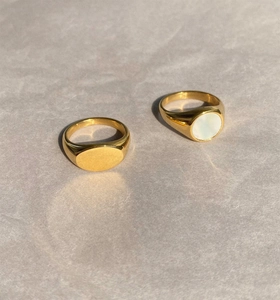 Close-up of gold signet rings featuring polished finish and white mother of pearl inlay