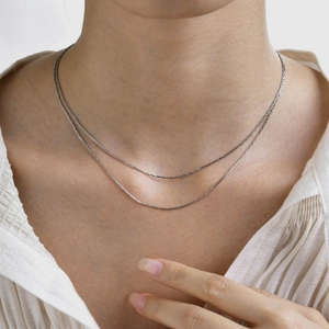 Vue détaillée d'un collier ras du cou minimaliste argenté à double épaisseur en acier