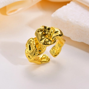 Macro shot of an adjustable gold ring featuring an abstract crumpled lava texture