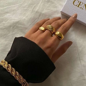 Set of three gold-plated rings and chunky chain bracelet worn by model in a stylish look