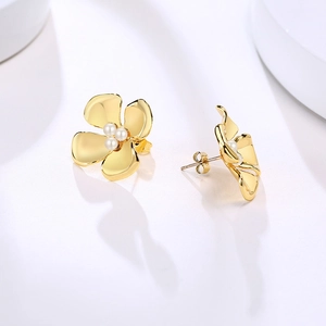 Detail of gold floral earrings with triple pearl inlay and secure butterfly backings