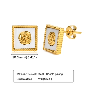 Détail de boucles d'oreilles carrées en acier doré avec nacre blanche et rose gravée