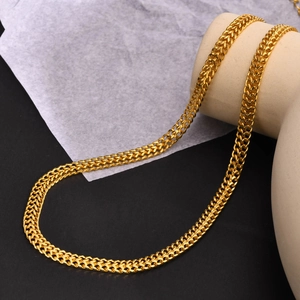 Collier double chaîne en acier titane doré au style minimaliste exposé sur un support