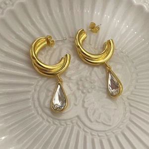 Detailed shot of gold C-shaped double hoop earrings with clear water-drop crystal pendants