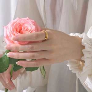 Elegant gold titanium steel double ring for women worn with a pink rose flower