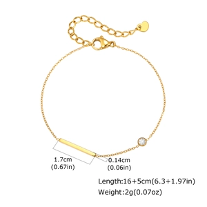 Détail du bracelet doré montrant le pendentif barre, le zircon et le fermoir mousqueton