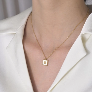 Collier doré élégant avec pendentif carré en nacre et rose en relief sur un mannequin
