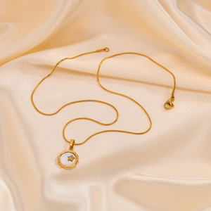 Collar de cadena de serpiente dorada con colgante de estrella y circonita sobre seda