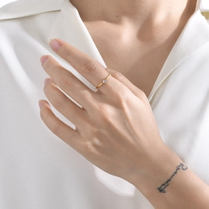 Minimalist gold titanium steel ring featuring a single square zircon on woman's finger