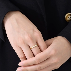 Bague minimaliste en acier inoxydable doré avec cristaux micro-pavés portée par un modèle