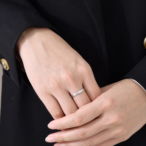 Gros plan d'une bague minimaliste en acier avec pavé de diamants sur le doigt