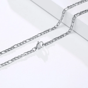 Polished silver Figaro chain necklace with lobster clasp on minimalist display