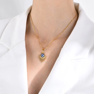 Χρυσό κολιέ με μενταγιόν Evil Eye φορεμένο από μοντέλο σε κομψό και μινιμαλιστικό στυλ