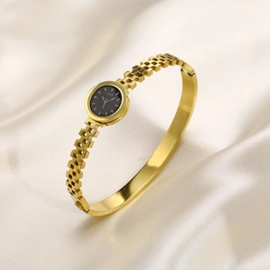 Detail of gold women's watch featuring black LOVE dial on smooth silk background