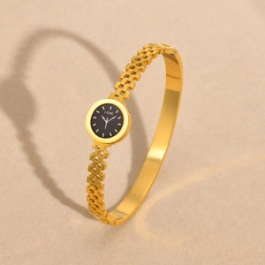 Elegant gold stainless steel bangle watch with black LOVE dial for women on sand surface