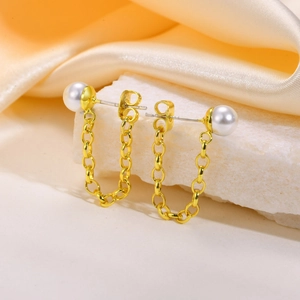 Orecchini a catena con perle dorate presentati su seta e pietre eleganti