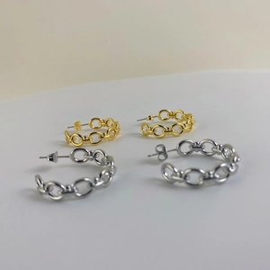 Dettaglio di orecchini a cerchio vintage stile francese a catena color oro e argento