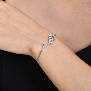 Detailed view of a silver rose flower bracelet worn on a woman's wrist with an elegant style