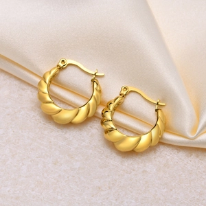 Créoles croissant en acier inoxydable doré 18K sur fond de soie beige élégant