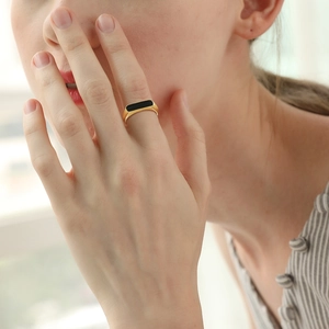Macro-opname van minimalistische vergulde roestvrijstalen ring met rechthoekige zwarte inleg