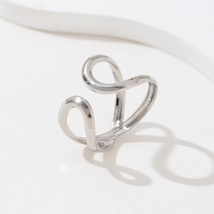 Close-up of a minimalist silver wavy open ring with a fluid modern artistic design