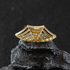 Gothic gold spider web stud earring on dark natural stone for Halloween jewelry styling