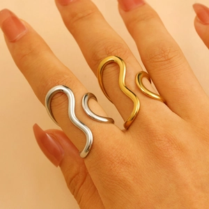 Minimalist gold and silver wavy open rings with a fluid line design on fingers