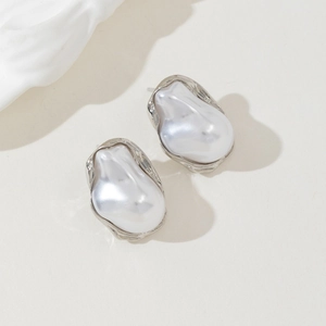 Close-up of irregular baroque pearl earrings with textured silver metal edges