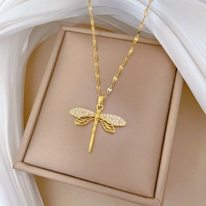 Elegant gold dragonfly pendant necklace with sparkling rhinestones on velvet jewelry box