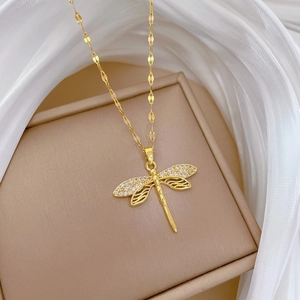 Detailed close-up of a golden dragonfly pendant with micro-pave zircons and hollow wings
