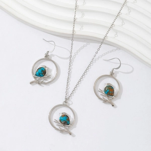 Silver necklace and earrings set featuring turquoise birds on branches in circles