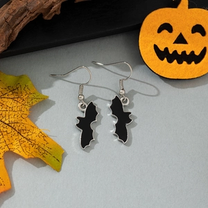 Halloween black bat drop earrings with silver hooks displayed on a festive autumn background