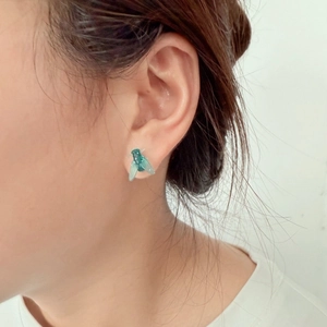 Boucle d'oreille mouche verte réaliste avec ailes transparentes portée par femme