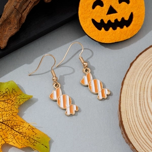 Gros plan sur des boucles d'oreilles bonbon à rayures avec décorations de citrouille
