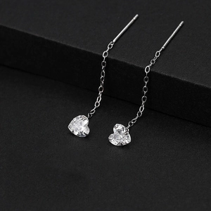 Elegant silver threader earrings with heart-shaped zircon stones on black background