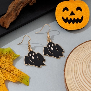 Détail de boucles d'oreilles fantômes d'Halloween en émail noir et cadre doré sur décor