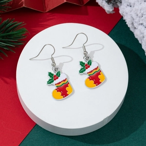 Festive Christmas stocking hook earrings with red and green holly details on a display stand