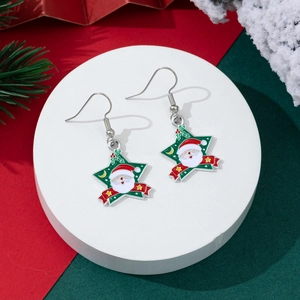 Detail of star-shaped Christmas earrings with Santa Claus motif on a festive background