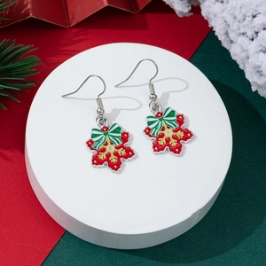 Close-up of Christmas drop earrings with festive red snowflake and striped bow detail