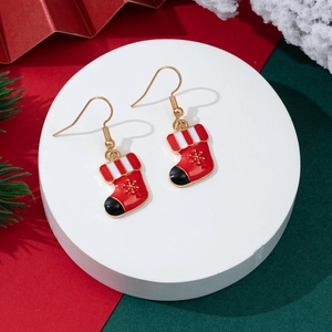 Detailaufnahme roter Emaille-Weihnachtssocken-Ohrringe mit goldenen Schneeflocken-Mustern