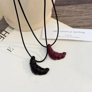 Ciondoli a forma di croissant su cordini neri nei colori nero e bordeaux lucido