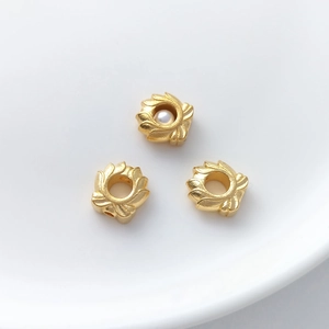 Detail of gold floral spacer beads with hollow design and pearl accents for DIY jewelry