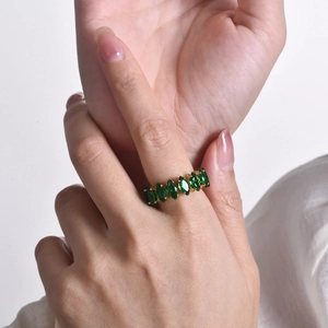 Gold stainless steel ring with marquise-cut green zircon gemstones on woman hand