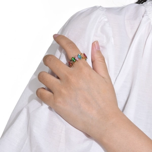 Detailed view of women's gold ring with colorful marquise-cut stones on a model
