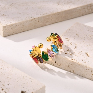Macro view of C-shaped gold-plated earrings set with colorful marquise-cut crystals
